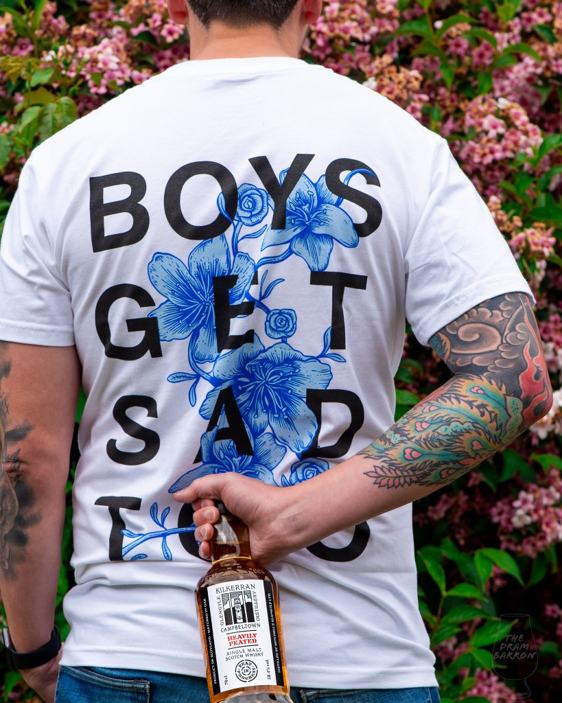 Kilkerran Heavily Peated Batch 8 Whisky held behind back with Boys Get Sad Too T-shirt on